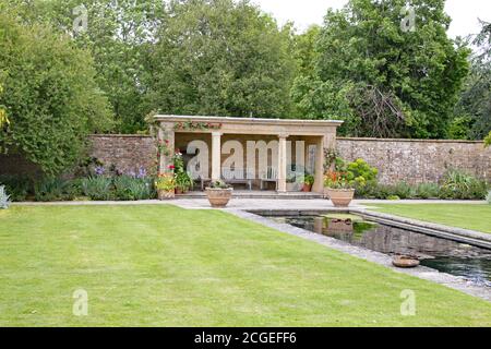 Coin salon couvert par un étang ornemental en anglais jardin de campagne Banque D'Images