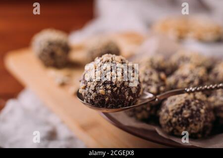 Boules de cacao, gâteaux de truffes au chocolat à bord sur fond de bois noix de cajou saupoudrées Banque D'Images