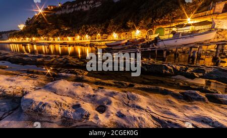 Plage de Passetto avec des grottes typiques de pêcheurs à Ancona - Marche - Italie, au coucher du soleil Banque D'Images