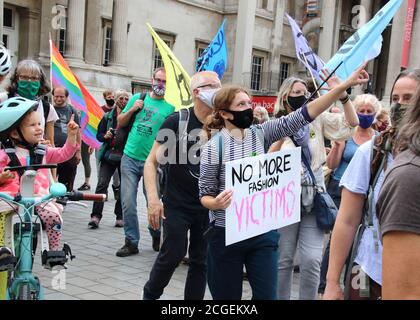 Une manifestante portant un masque de facial porte un écriteau intitulé « plus de victimes de la mode » pendant la manifestation.extinction les manifestants de la rébellion défilent à Westminster dans le cadre de leur journée de protestation contre l'injustice, s'opposant aux nombreuses injustices humaines, animales et environnementales de l'industrie de la mode. Banque D'Images