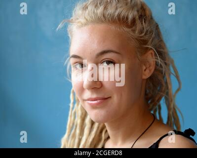 Jeune femme caucasienne avec des dreadlocks blonds pose pour la caméra. Banque D'Images