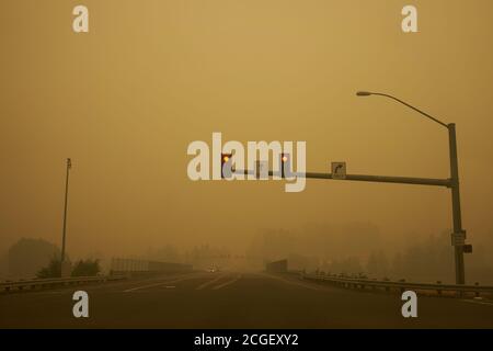 Feu de circulation sur la route contre le ciel rouge flamboyant avec des fumées des feux de forêt de l'Oregon en 2020. Banque D'Images