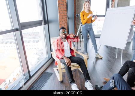 Jeune entraîneur d'affaires, homme et femme, employé de bureau préparant la présentation debout ensemble devant un tableau de conférence avec un graphique sur elle Banque D'Images