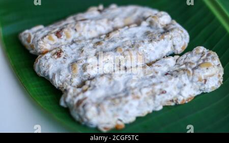 Oncom noir sur fond de feuille de banane. Oncom est l'un des aliments de base traditionnels de la cuisine javanaise occidentale (Sundanese) de l'Indonésie. Banque D'Images