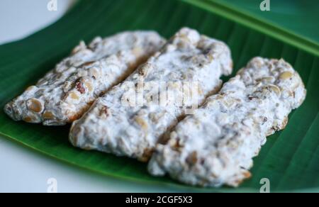 Oncom noir sur fond de feuille de banane. Oncom est l'un des aliments de base traditionnels de la cuisine javanaise occidentale (Sundanese) de l'Indonésie. Banque D'Images