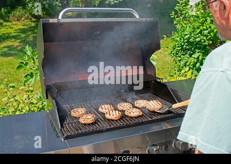 Personne qui fait griller de délicieuses viandes dans un barbecue à fumée un beau jour d'été -11 Banque D'Images