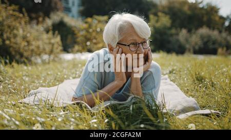 femme âgée appréciant la journée d'automne ensoleillée dans le parc. Photo de haute qualité Banque D'Images