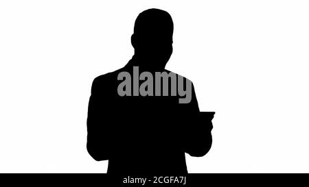 Silhouette homme d'affaires lisant ou travaillant sur une tablette numérique. Banque D'Images