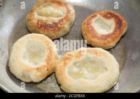 Cuisson de quatre morceaux de bhatura frits dans une casserole Banque D'Images