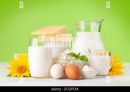 Divers produits laitiers. Lait, fromage, cottage, crème sure. Devant un arrière-plan vert Banque D'Images