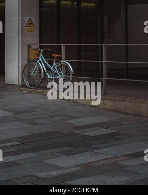 Un vélo bleu solitaire appuyé contre les rampes à l'extérieur de Manchester Crown Cour Banque D'Images