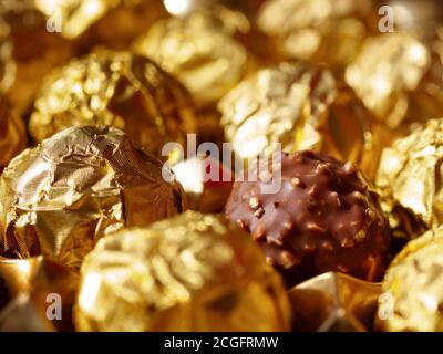 Boules de chocolat en feuille d'or vue du dessus, une praline en feuille d'emballage ouverte Banque D'Images