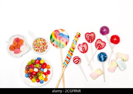 Bonbons et sucettes assortis sur fond blanc dans un vue de dessus Banque D'Images