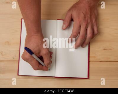 Les mains de l'auteur qui met son autographe sur une page vierge dans un nouveau livre Banque D'Images