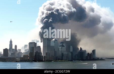 Une épaisse fumée noire émerge des tours en feu du World Trade Center, dans le quartier de New York, à Manhattan, le matin du 9/11/2001. L'épave et les parties du bâtiment des tours jumelles de 411 mètres de haut volent sur la rue. Peu avant, deux avions avaient couru l'un derrière l'autre dans les deux tours. Outre les occupants des machines, la plupart des personnes à l'intérieur des deux gratte-ciel ont été tuées dans les explosions importantes. Le FBI soupçonne qu'il s'agit d'une attaque ciblée par des terroristes kamikazes. Les parties supérieures des gratte-ciels ont été enflamées après des explosions. La machin Banque D'Images