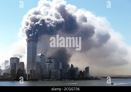 Une épaisse fumée noire émerge des tours en feu du World Trade Center, dans le quartier de New York, à Manhattan, le matin du 9/11/2001. Peu avant, deux avions avaient couru l'un derrière l'autre dans les deux tours. Outre les occupants des machines, la plupart des personnes à l'intérieur des deux gratte-ciel ont été tuées dans les explosions importantes. Le FBI soupçonne qu'il s'agit d'une attaque ciblée par des terroristes kamikazes. Les parties supérieures des gratte-ciels ont été enflamées après des explosions. Des parties de l'épave et des bâtiments des tours jumelles de 411 mètres de haut ont volé sur la rue. Le Banque D'Images