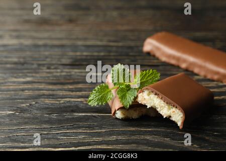 Barres à la menthe et à la noix de coco en chocolat sur fond de bois Banque D'Images