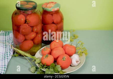 Tomates marinées en pots . Des tomates fraîches avec de l'ail et des herbes sont sur une assiette. Orientation horizontale. Banque D'Images