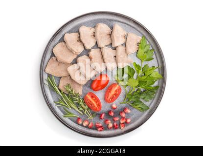 La langue de porc bouillie avec des tomates et des herbes isolées sur fond blanc. Vue de dessus, gros plan, plan à plat. Banque D'Images