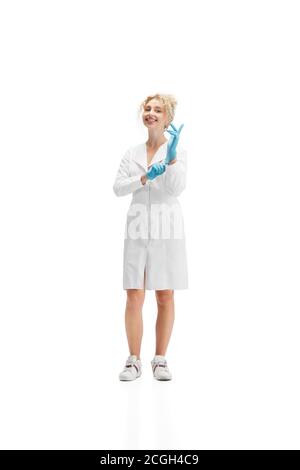 Portrait d'une femme médecin, infirmière ou cosmétologue en uniforme blanc portant des gants bleus sur fond blanc de studio. CopySpace pour publicité. Concept de soins de santé et de médecine, beauté, autosoins. Banque D'Images