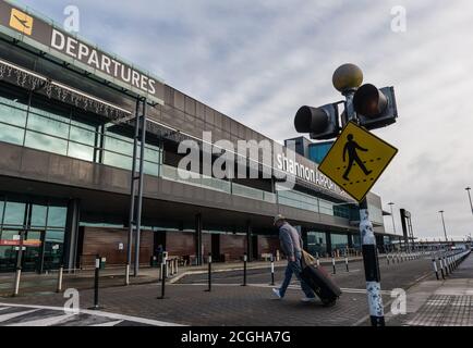 Aéroport de Shannon, Irlande - 21 novembre 2016 : homme marchant avec des bagages vers le bâtiment des départs de l'aéroport de Shannon en République d'Irlande. Banque D'Images