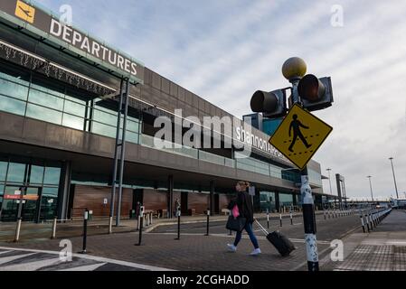 Aéroport de Shannon, Irlande - 21 novembre 2016 : une femme marchant avec ses bagages vers le bâtiment des départs de l'aéroport de Shannon en République d'Irlande. Banque D'Images