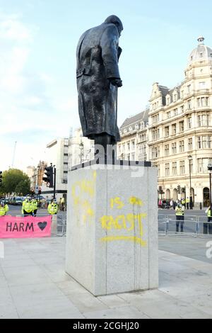 Un manifestant de la rébellion d'extinction défait la statue de Winston Churchill sur la place du Parlement au cours du dernier jour de la manifestation des groupes à Londres. Banque D'Images