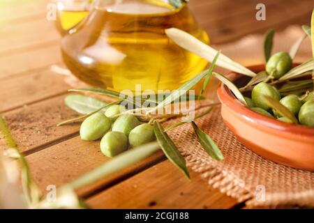 Olives de l'arbre sur une table en bois avec un récipient plein de détail d'huile d'olive. Vue en hauteur.