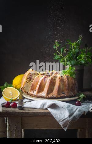 Gâteau bundt citron fait maison de sucre glace sur un fond noir Banque D'Images