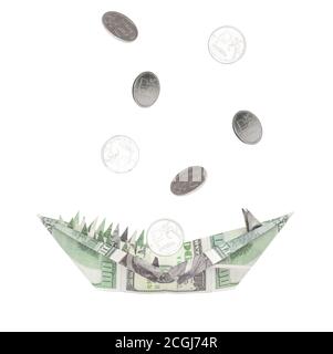 Une figure d'origami faite de dollars sous forme de tête d'un animal avec des dents et une bouche ouverte. Les pièces de monnaie roubles se déversent dans la bouche des dollars. La conce Banque D'Images