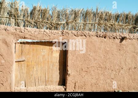 Un mur et une porte dans le vieux quartier du village médiéval de boue saharienne d'al Qasr, dans l'oasis de Dakhla, dans le désert occidental du Sahara, en Égypte. Banque D'Images