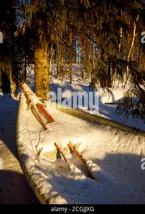 Paire de verriers en bois et un bateau à rames / skiff plein de neige et de glace à Winter , Finlande Banque D'Images