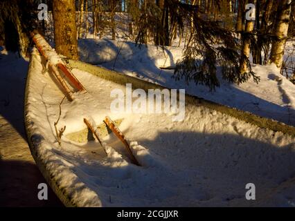 Paire de verriers en bois et un bateau à rames / skiff plein de neige et de glace à Winter , Finlande Banque D'Images