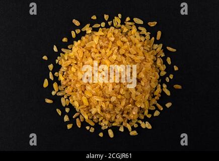 Grains de blé bulgur isolés sur fond noir Banque D'Images