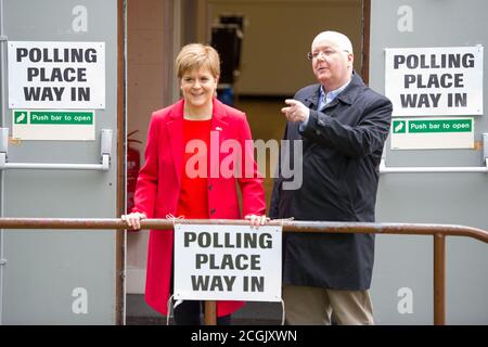 Uddingston, Écosse, Royaume-Uni. Photo : (à gauche) Nicola Sturgeon - Premier ministre d'Écosse et chef du Parti national écossais (SNP), vu avec son mari, (à droite) Peter Murrell PDG du Parti national écossais (SNP), Visite de son bureau de vote local pour voter aux élections européennes pour que le SNP garde l'Écosse en Europe. Crédit : Colin Fisher/Alay Live News. Banque D'Images