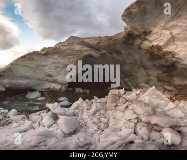 Entrée à la grotte de neige du glacier Alibek À Dombay avec de hauts murs de neige gelée Banque D'Images