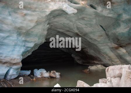 Entrée à la grotte de neige du glacier Alibek À Dombay avec de hauts murs de neige gelée Banque D'Images