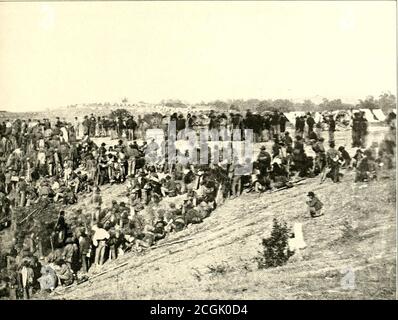 . L'histoire photographique de la guerre civile : en dix volumes . LA PRÉPARATION DES RATIONS DES CONQUÉRANTS Capture n'était pas un mal inmitigé pour les soldats confédérés dans la campagne Wilderness. L'Armyof Northern Virginia avait déjà percé sa ceinture en raison de la défaillance des approvisionnements; Hutte les troupes de l'Union ont été abondamment approvisionnées en wagons-trains, et les hommes en gris qui ont été capturés près de leur base de fournitures à Belle Plain étaient sûrs au moins d'un bon repas. Les prisonniers confédérés ont été capturés à Spotsylvania, le 12 mai 18C4, par le deuxième corps sous la direction du général Han Banque D'Images