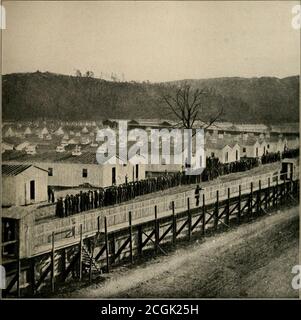 . L'histoire photographique de la guerre civile : des milliers de scènes photographiées 1861-65, avec le texte de nombreuses autorités spéciales . APPEL D'APPEL EN SOIRÉE POUR LES PRISONNIERS D'ELMIRA 1864 cette photographie a été chérie par Berry Benson, de la première infanterie de volun-teer de Caroline du Sud, qui s'est échappée d'Elmira en creusant un tunnel de soixante-six pieds de long sous les tentes et la stockade.elle montre les prisonniers en soirée appel à dîner à l'hiver 1864. Les sergents devant la ligne de prisonniers tout au long de la vie appellent le rôle. Il y avait à la fois des sergents fédéraux et confédérés. Elmirapri Banque D'Images