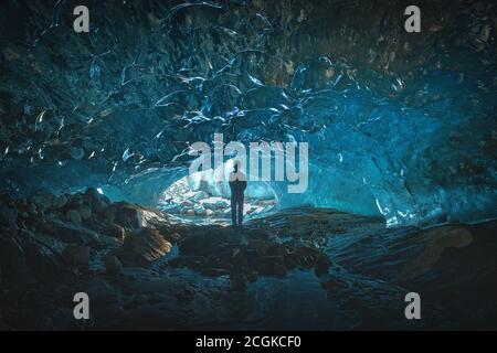 Personne grotte de glace dans un glacier de montagne, une colonne de glace la plus pure surplombe les pierres de la grotte Alibek, glacier Dombay, Russie Banque D'Images