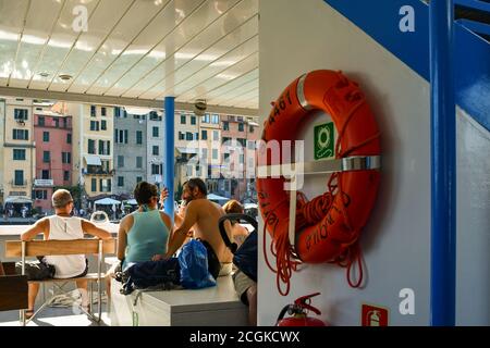 Personnes à bord d'un bateau touristique au départ du port de Porto Venere, un vieux village de pêcheurs classé au patrimoine mondial de l'UNESCO, la Spezia, Ligurie, Italie Banque D'Images