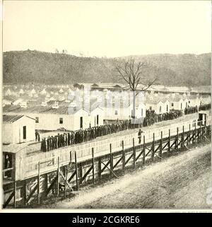 . L'histoire photographique de la guerre civile : en dix volumes . APPEL D'APPEL EN SOIRÉE POUR LES PRISONNIERS D'ELMIRA 1864 cette photographie a été chérie par Berry Benson, de la première infanterie de volun-teer de Caroline du Sud, qui s'est échappée d'Elmira en creusant un tunnel de soixante-six pieds de long sous les tentes et la stockade.elle montre les prisonniers en soirée appel à dîner à l'hiver 1864. Les sergents devant la ligne de prisonniers tout au long de la vie appellent le rôle. Il y avait à la fois des sergents fédéraux et confédérés. Elmiraprison contenait depuis l'époque de sa création plusieurs milliers Banque D'Images