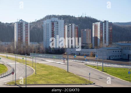 Zone résidentielle urbaine avec maisons et jonction de route sur le fond d'une montagne boisée, à Krasnoyarsk à l'automne. Banque D'Images