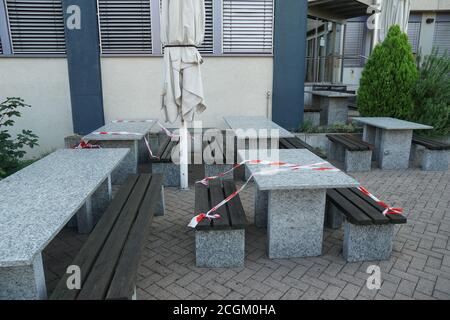 Restaurant vide avec ruban barrière rouge et blanc qui, comme une nouvelle norme à fixer toutes les deux tables afin de maintenir la distance sociale. Banque D'Images