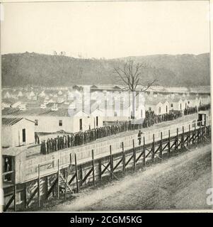 . L'histoire photographique de la guerre civile : des milliers de scènes photographiées 1861-65, avec le texte de nombreuses autorités spéciales . COPVRIGMT. 1911, REVIEW OF REVIEWS CO. EVENING ROLI^CALL FOR THE ELMIRA PENIAPHS-1864 ce pliotofiraph a été chéri à travers un demi-siècle par Berry Benson, de la première infanterie de volun-teer de Caroline du Sud, ^vho s'est échappée d'Elmira en creusant un tunnel de soixante-six pieds de long sous les tentes et la stockade.IT slunvs les prisonniers à la soirée appel à dîner à l'hiver 1864. Les sergents devant la ligne de prisonniers Ions appellent le rouleau. Il y avait les deux F Banque D'Images
