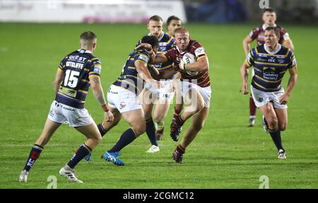 Oliver Wilson de Huddersfield Giants est attaqué par Konrad Hurrell de Leeds Rhinos (à gauche) lors du match de la Super League de Betfred au stade totalement Wicked, à St Helens. Banque D'Images