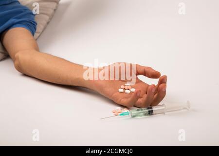 Concept de toxicomanie - main passive avec le pelage, les pilules et l'injection, sur fond blanc et isolé Banque D'Images