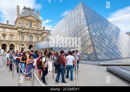 Les personnes qui se tiennent en file d'attente pour entrer au Musée du Louvre À Paris Banque D'Images