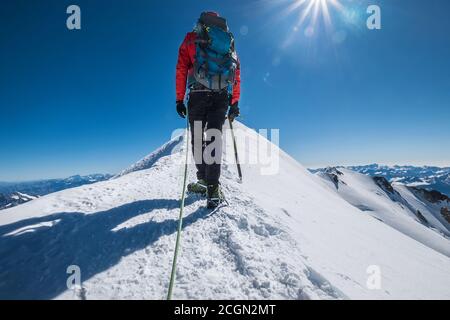 Derniers pas avant le sommet du Mont blanc (Monte Bianco) 4,808 m d'homme avec hache d'escalade vêtements d'alpinisme habillés, bottes avec crampons marchant par sno Banque D'Images