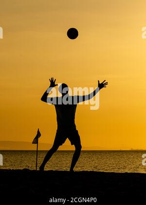 Silhouettes de Beach-volley au coucher du soleil jaune Banque D'Images